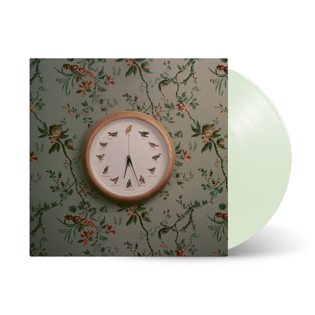 Image of Valleyheart Heal My Head Album Cover with the vinyl exposed to show its coloring, on a white background. Cover is floral wallpaper like background with a clock that has various birds instead of numbers. 