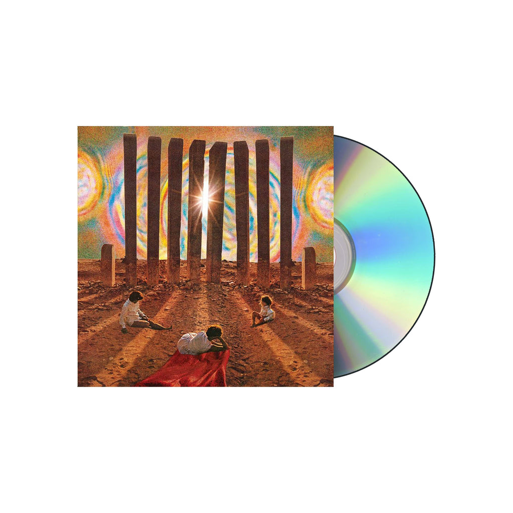 image of a cd on the right. album cover is on the left and shows a desert scene with pillars and three people on the ground staring into the sun,
