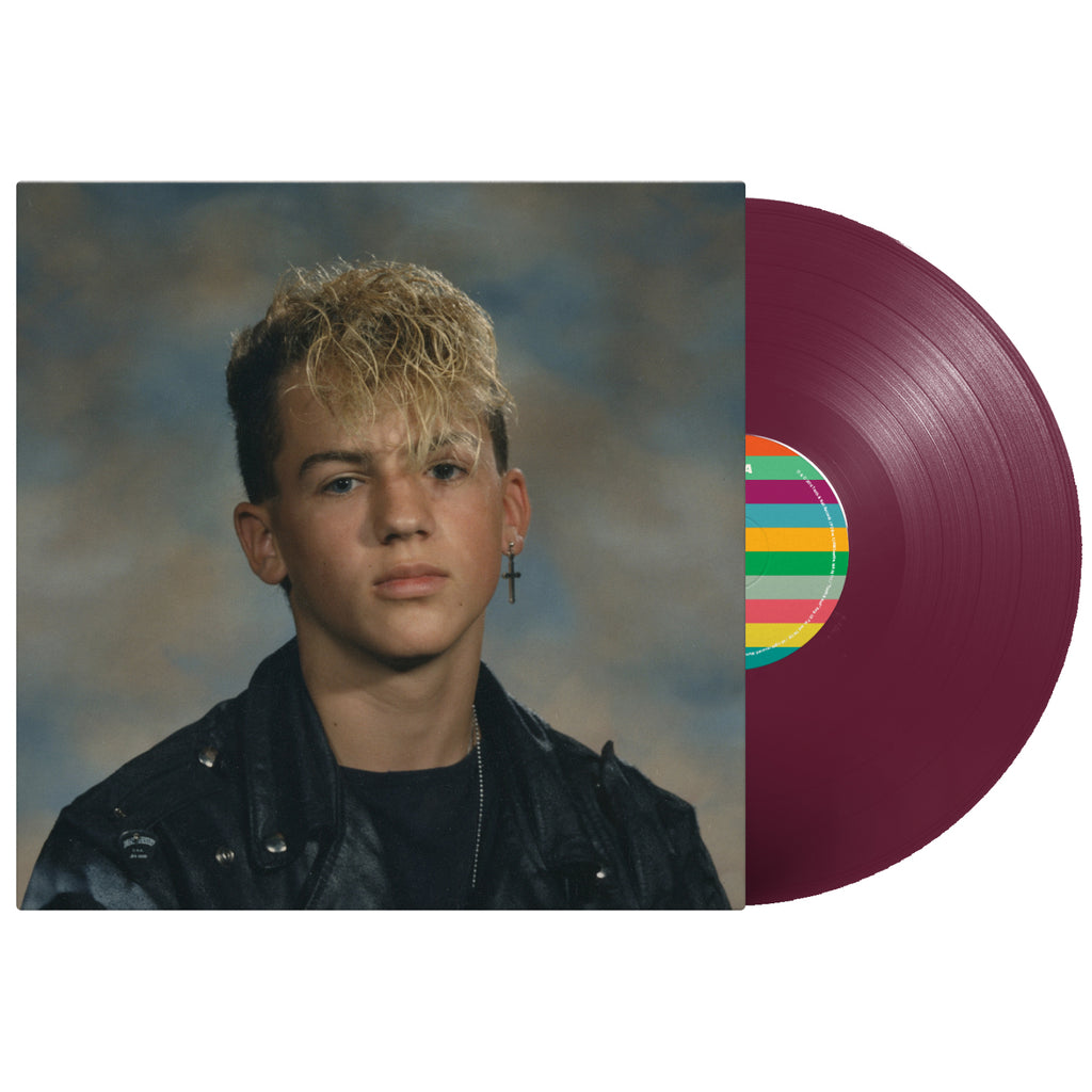 image of a prurple vinyl record on the right coming out of the sleeve. the cover is a young man's school portrait. he has blonde hair and a cross earring on his right ear.