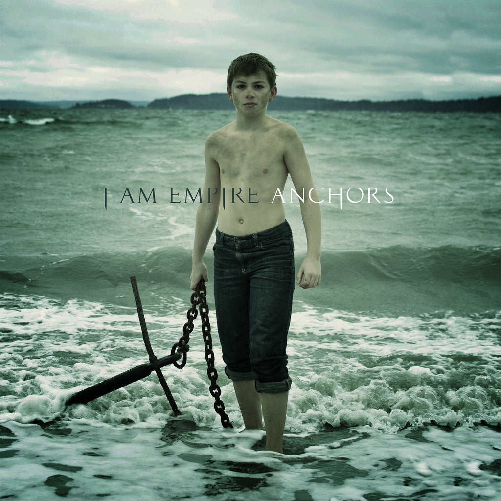 image of an album cover. cover is of a young boy on the beach, standing in the water holding a chain to an anchor. across the center says i am empire anchors