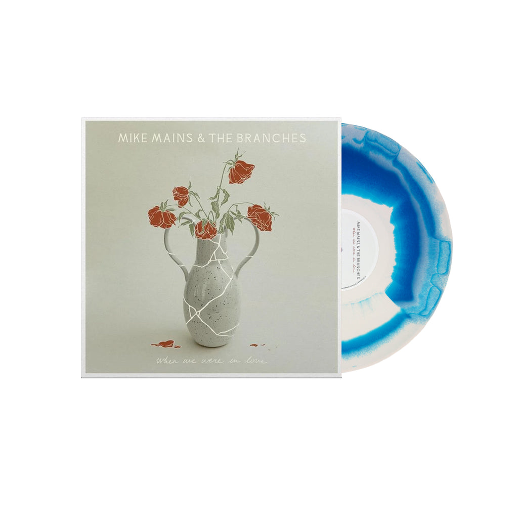 image of a bone and blue aqua vinyl record on the right. album cover on the left. image of an album cover. at the top says mike mains & the branches. there is a cracked vace in the center, with illustrated red roses. at the bottom says when we were in love